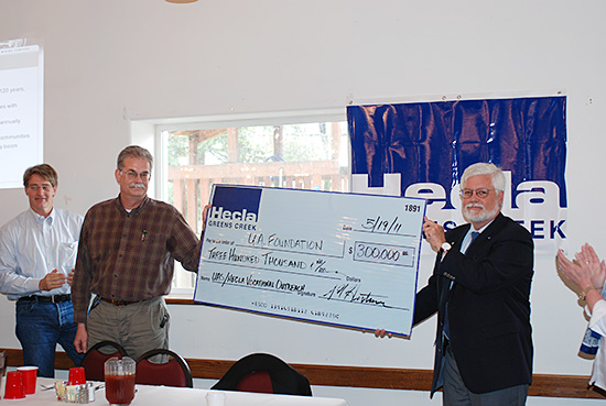 Hecla Greens Creek Mining Company CEO Phil Baker (holding check) and General Manager Scott Hartman present a check for the Career Pathways in Mining program to UAS Chancellor John Pugh.